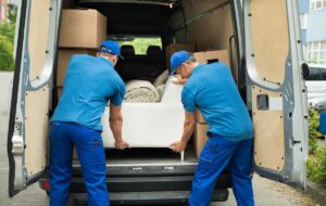 A man and a van team loading furniture into a van